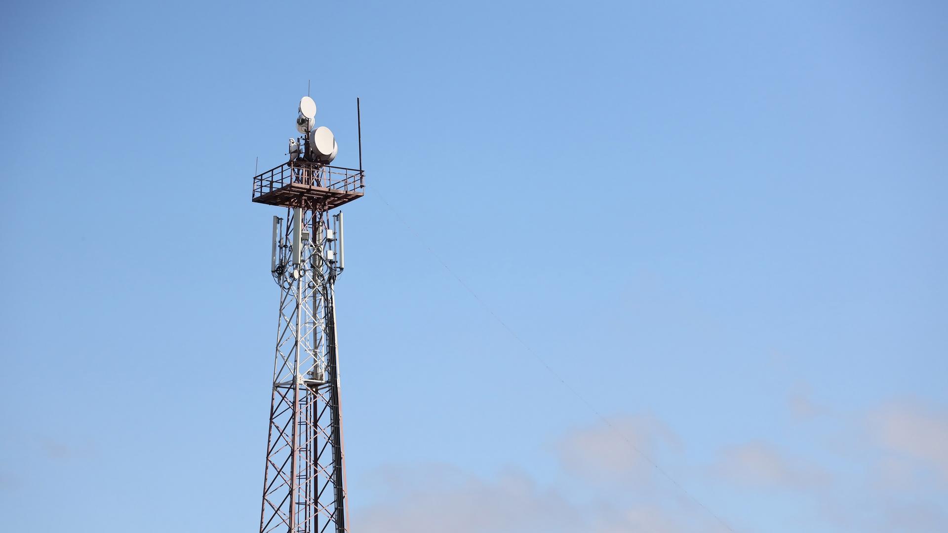 Telekommunikations-Antennen-Turm mit 4G und 5G vor einem blauen Himmel.