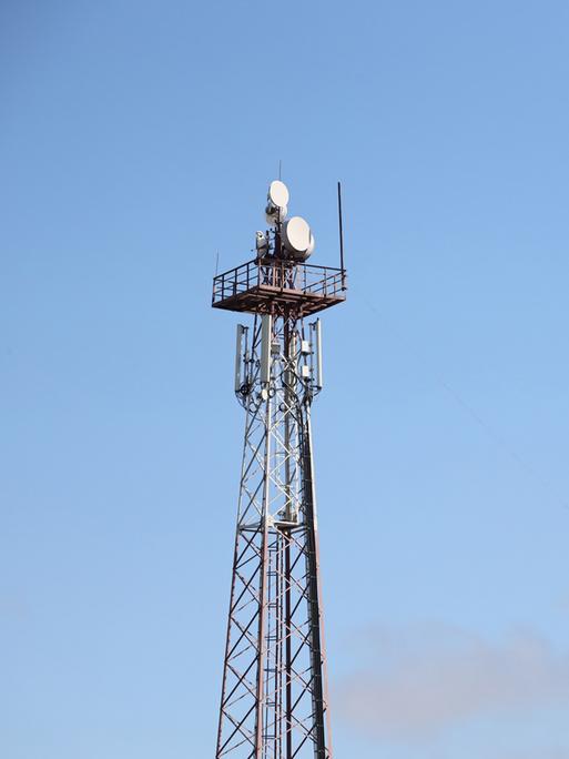 Telekommunikations-Antennen-Turm mit 4G und 5G vor einem blauen Himmel.