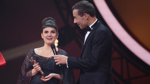 Miriam Peters in schwarzem Kleid nimmt während der Verleihung „Goldene Bild der Frau“ im Stage Theater an der Elbe auf der Bühne die Auszeichnung von Kai Pflaume entgegen.