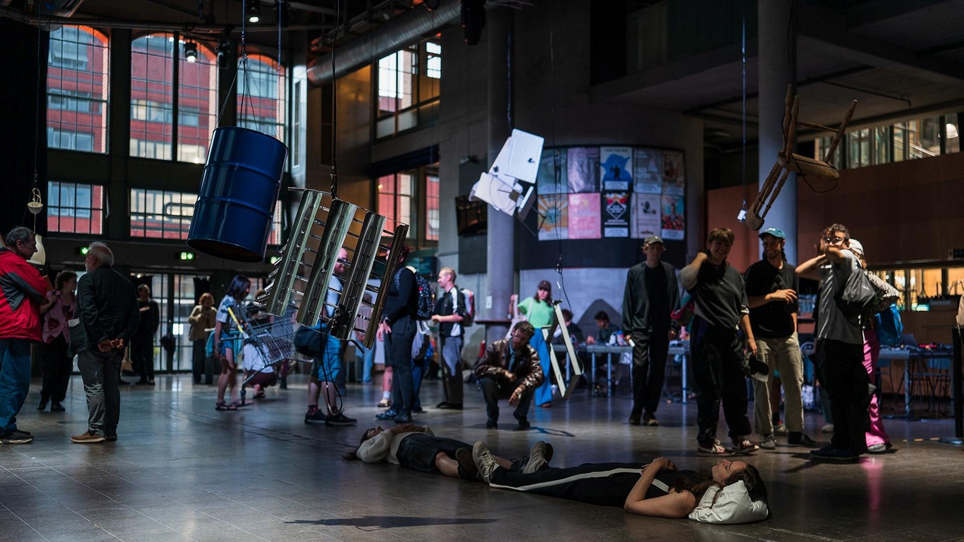Gruppen von stehenden und liegenden Musikern und Besuchern bevölkern den Konzertsaal der Centralstation in Darmstadt. Gruppen von stehenden und liegenden Musikern und Besuchern bevölkern den Konzertsaal der Centralstation in Darmstadt.