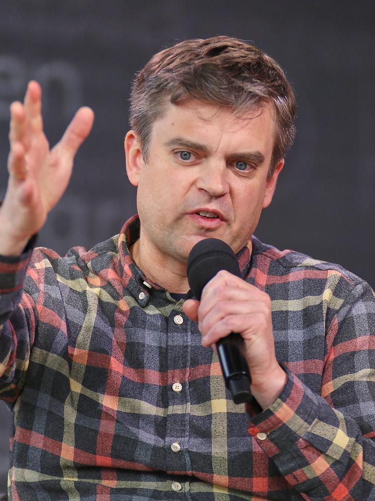 Matthias Nawrat sitzt in einem karierten Hemd in Leipzig, Sachsen, au der Bühne und spricht.