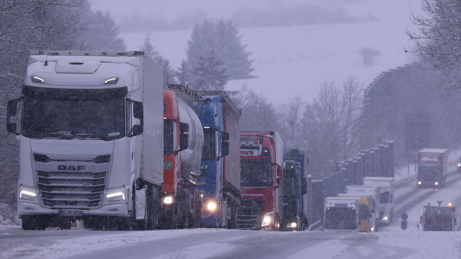 Nordrhein-Westfalen, Blankenheim: Lastkraftwagen stauen sich an einer Steigung nach einem Unfall bei starkem Schneefall auf der B51 bei Blankenheim.