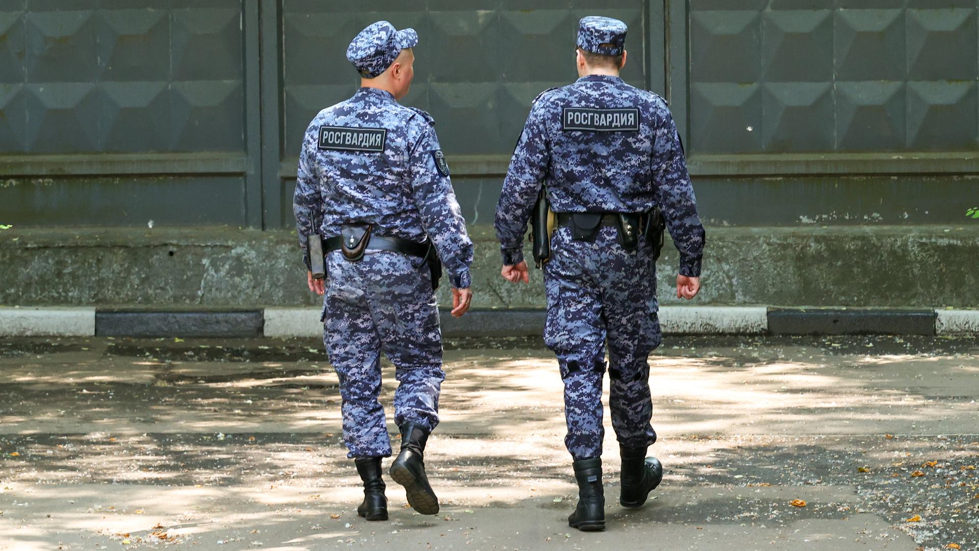 Zwei russische Soldaten laufen in Militäruniform einem Tor entgegen.