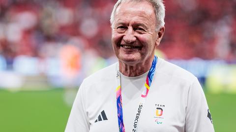 Friedhelm Julius Beucher trägt Sportkleidung und steht in einem Stadion.