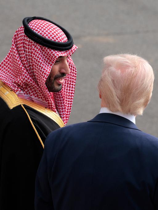 Donald Trump und Mohammed bin Salman stehen nebeneinander auf einem Rollfeld und sprechen miteinander. Donald Trump und Mohammed bin Salman stehen nebeneinander auf einem Rollfeld und sprechen miteinander.