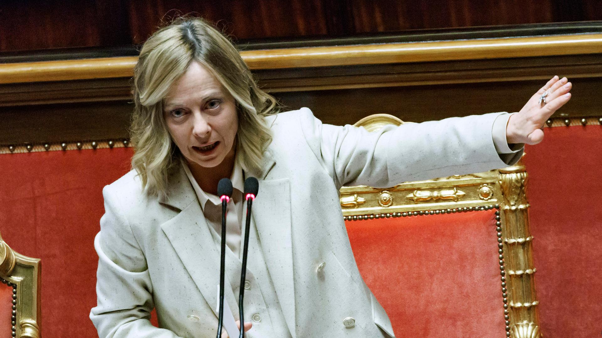 Italiens Premierministerin Meloni gestikuliert am Rednerpult. 