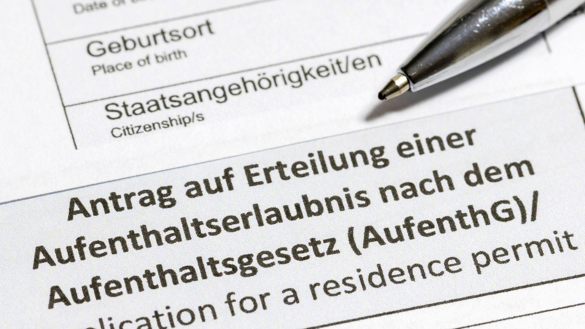 Ein Antrag auf Erteilung einer Aufenthaltserlaubnis in Nahaufnahme mit einem Kugelschreiber