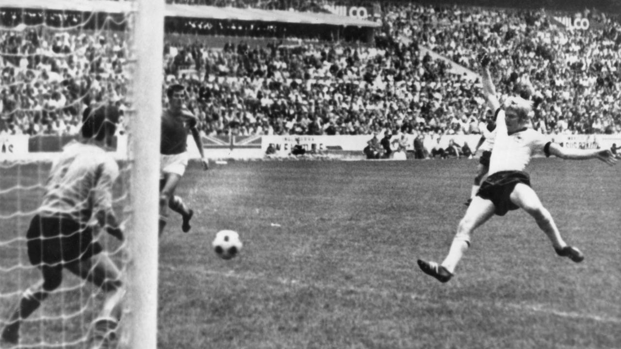 Die Schwarz-Weiß-Aufnahme zeigt einen Fußballspieler bei einem Torschuss.