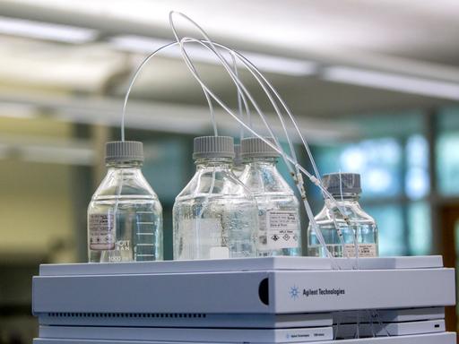 Kleine Fläschchen, in denen transparente Schläuche stecken. Kleine Fläschchen, in denen transparente Schläuche stecken.