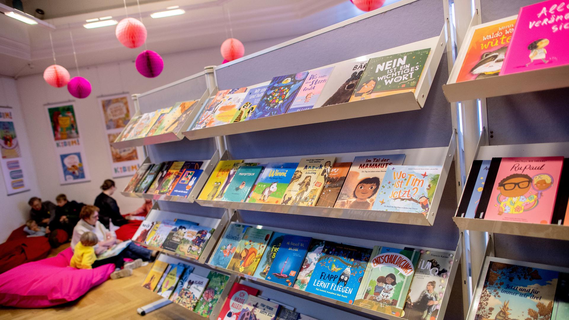 Farbige Bücher liegen in einem Regal bei der Kinder- und Jugendbuchmesse KIBUM 2025 in Oldenburg.