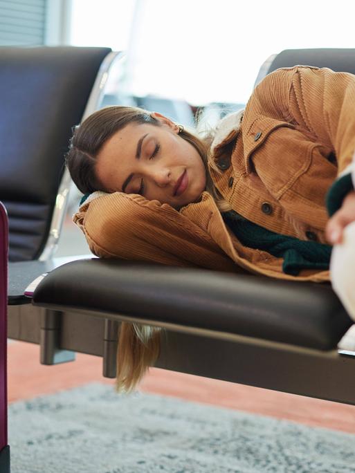 Schlafende Touristin an einem Flughafen