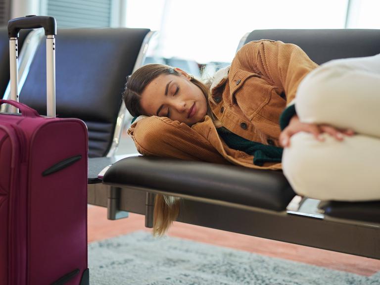 Schlafende Touristin an einem Flughafen