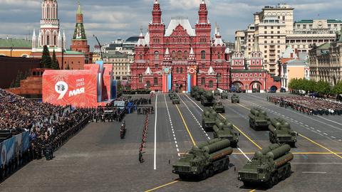  Militärfahrzeuge fahren über den Roten Platz in Moskau an einer Tribüne vorbei. 