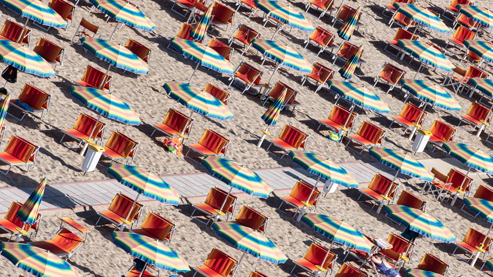 Liegen und Sonnenschirme am Strand der adriatischen Riviera in Italien