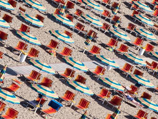 Liegen und Sonnenschirme am Strand der adriatischen Riviera in Italien