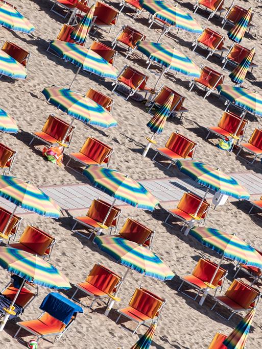 Liegen und Sonnenschirme am Strand der adriatischen Riviera in Italien