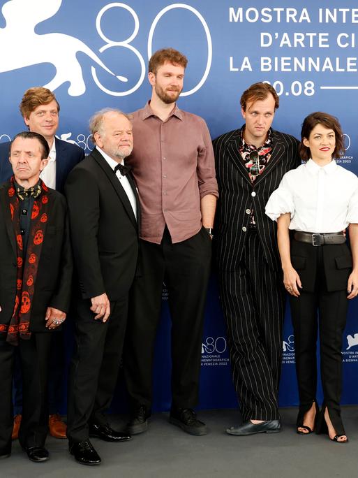 David Bennent, Philippe Graber, Gottfried Breitfuss, Timm Kröger, Jan Bülow, Olivia Ross und Hanns Zischler stehen beim Photocall zum Kinofilm "Die Theorie von Allem" auf der Biennale di Venezia 2023 vor einer Fotowand.