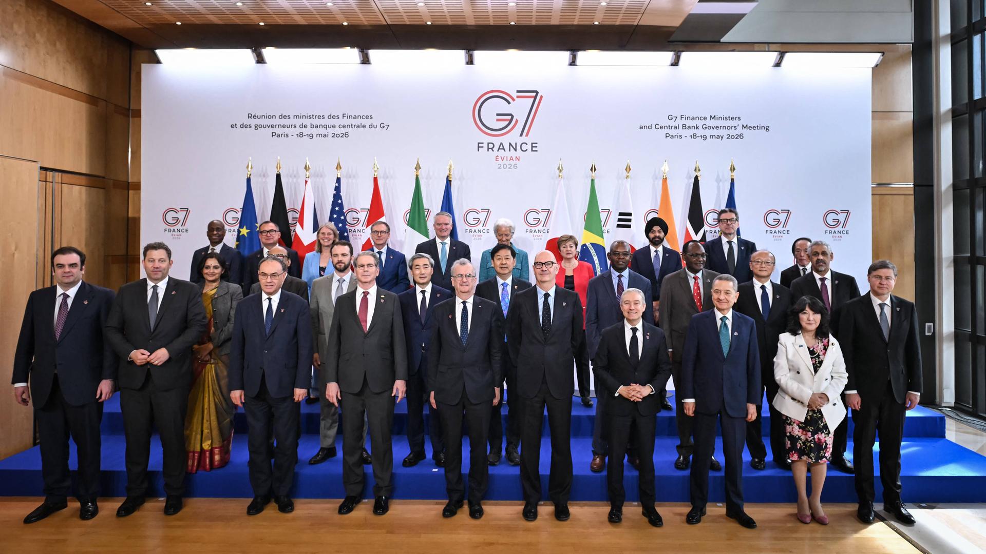 Eine Gruppe von Personen posiert beim Treffen der Finanzminister der G7-Staaten für ein Gruppenfoto. Im Hintergrund sind Flaggen mehrerer Staaten.