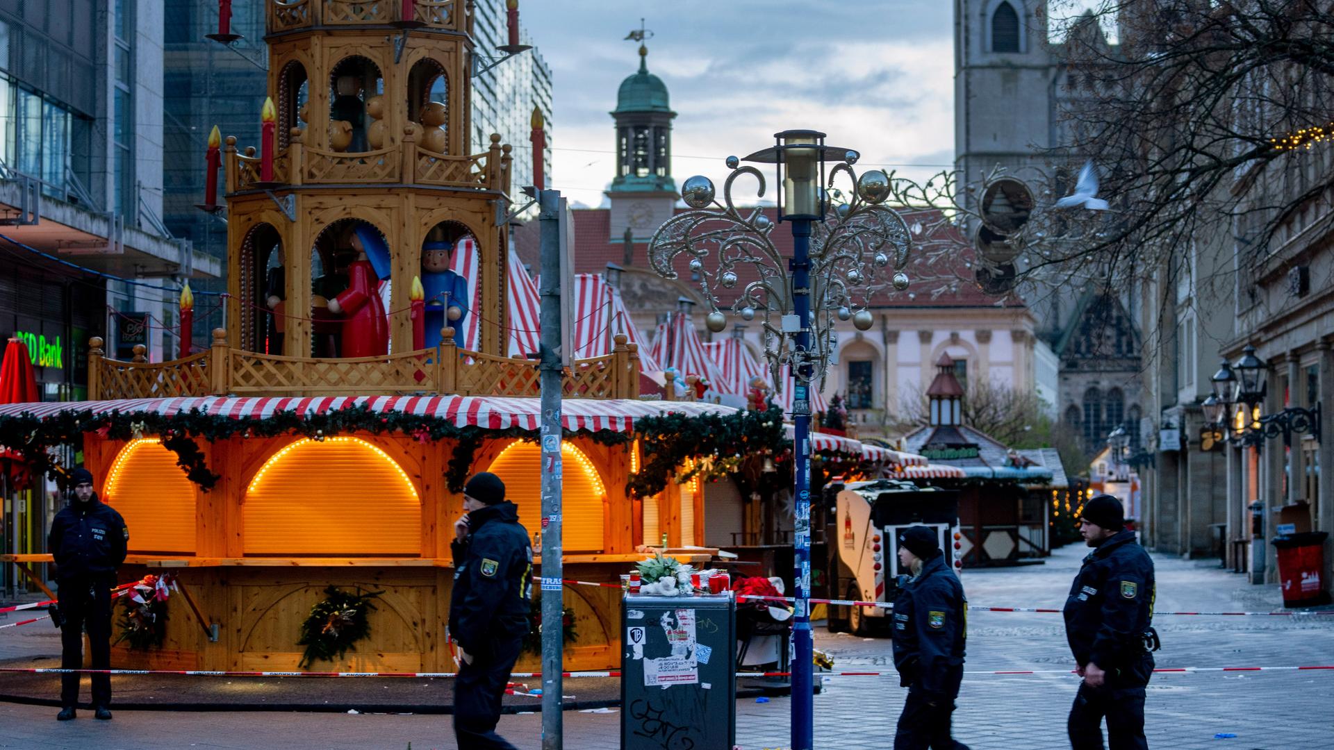 Das Bild zeigt Polizisten, die am abgesperrten Tatort in Magdeburg patrouillieren.