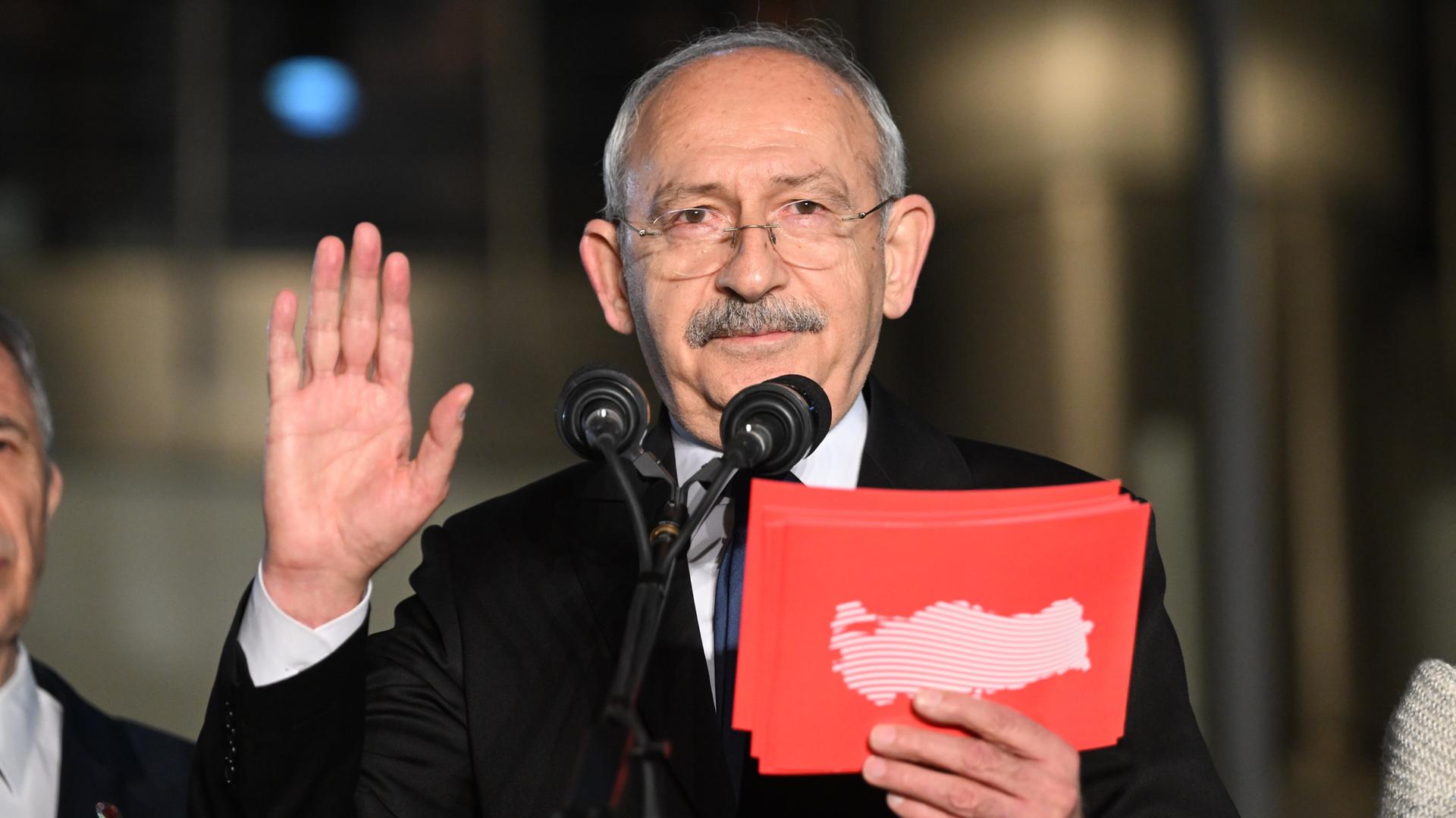 Der Politiker Kemal Kilicdaroglu bei einer Rede an einem Mikrophon. in der Hand hält er rote Karteikarten. 