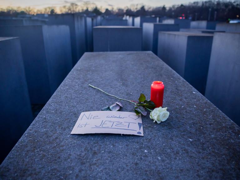 Eine Kerze, eine Rose sowie ein Schild mit der Aufschrift «Nie wieder jetzt!» liegen anlässlich des Internationalen Tags des Gedenkens an die Opfer des Holocaust auf einer Stele des Denkmals für die ermordeten Juden Europas.