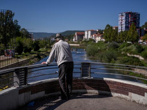 Ein kosovo-albanischer Mann blickt von einer Brücke in der tief geteilten Stadt Mitrovica 