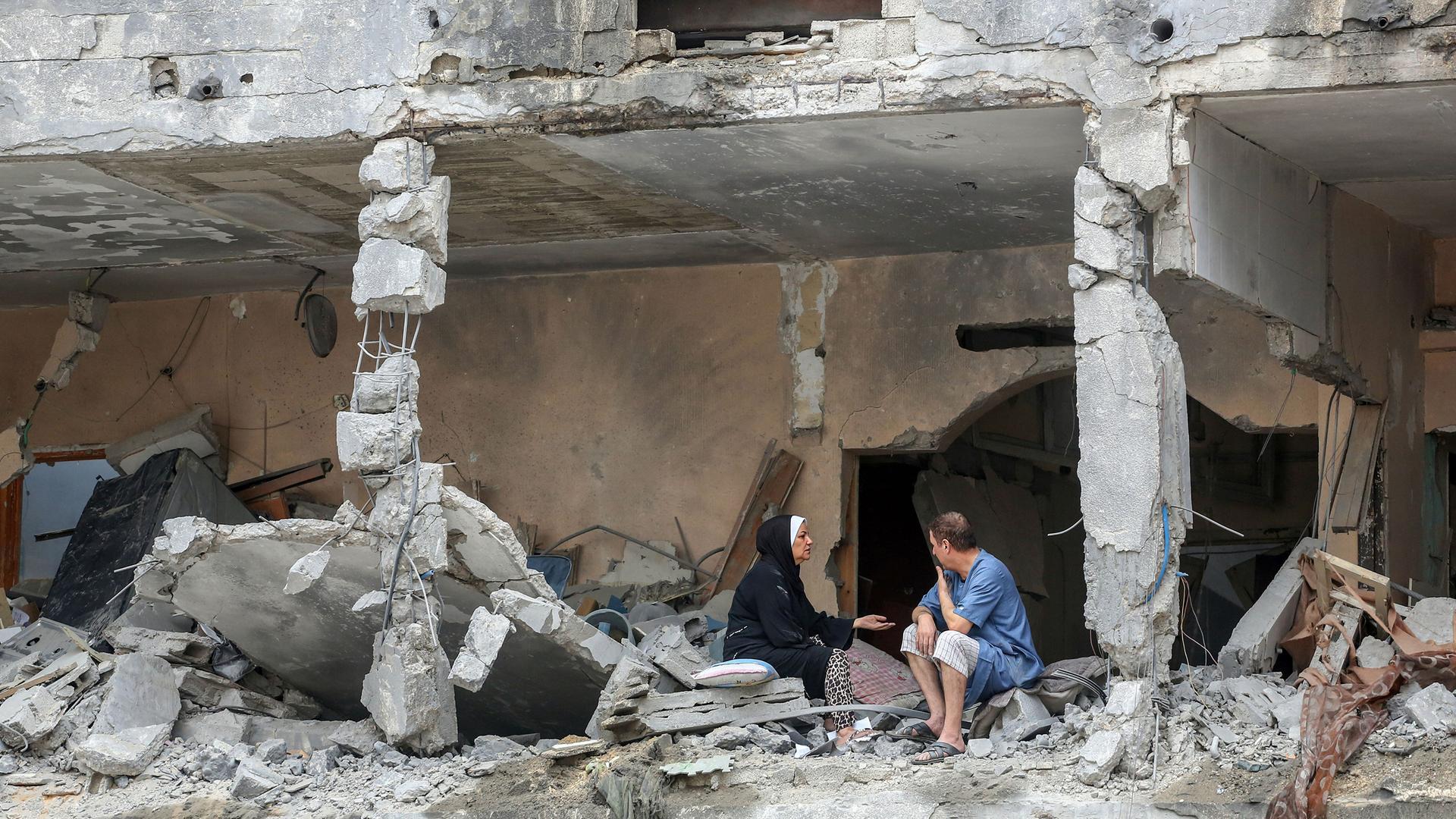 10. Oktober 2023, Gaza, Palästina: Palästinenser sitzen nach israelischen Angriffen in Gaza-Stadt zwischen den Trümmern eines beschädigten Wohngebäudes. Israel hat nach eigenen Angaben die Grenzgebiete des Gazastreifens von der Hamas zurückerobert. Am 10. Oktober, dem vierten Tag der zermürbenden Kämpfe seit dem Überraschungsangriff der Islamisten, wurden mehr als 3.000 Menschen getötet.