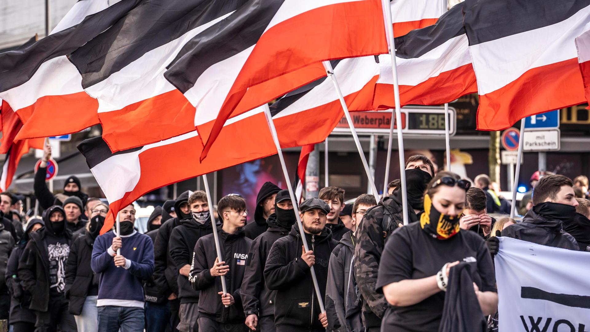 Die Neonazi-Gruppe "Jung und Stark" (JS) demonstriert im März 2025 schwarz gekleidet und Reichsflaggen tragend in der Essener Innenstadt für Abschiebungen von Ausländern.
