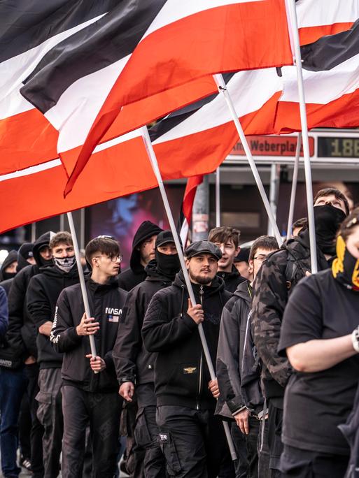 Die Neonazi-Gruppe "Jung und Stark" (JS) demonstriert im März 2025 schwarz gekleidet und Reichsflaggen tragend in der Essener Innenstadt für Abschiebungen von Ausländern.
