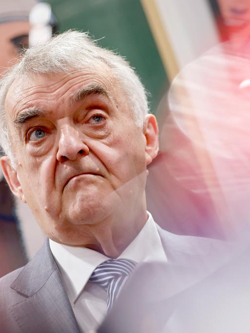 NRW-Innenminister Herbert Reul (CDU), hier am Stand des Landesamtes für Verfassungsschutz auf der weltgrößten Computerspielmesse Gamescom 2025 in  Köln. Er schaut in die Kamera vor buntem Hintergrund.