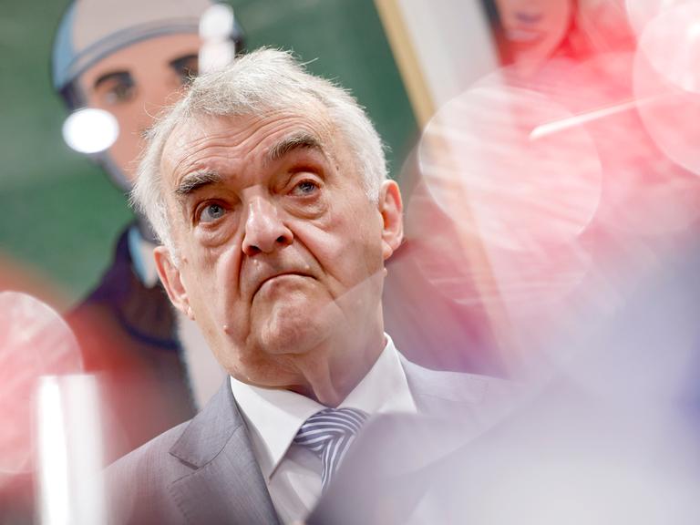 NRW-Innenminister Herbert Reul (CDU), hier am Stand des Landesamtes für Verfassungsschutz auf der weltgrößten Computerspielmesse Gamescom 2025 in  Köln. Er schaut in die Kamera vor buntem Hintergrund.