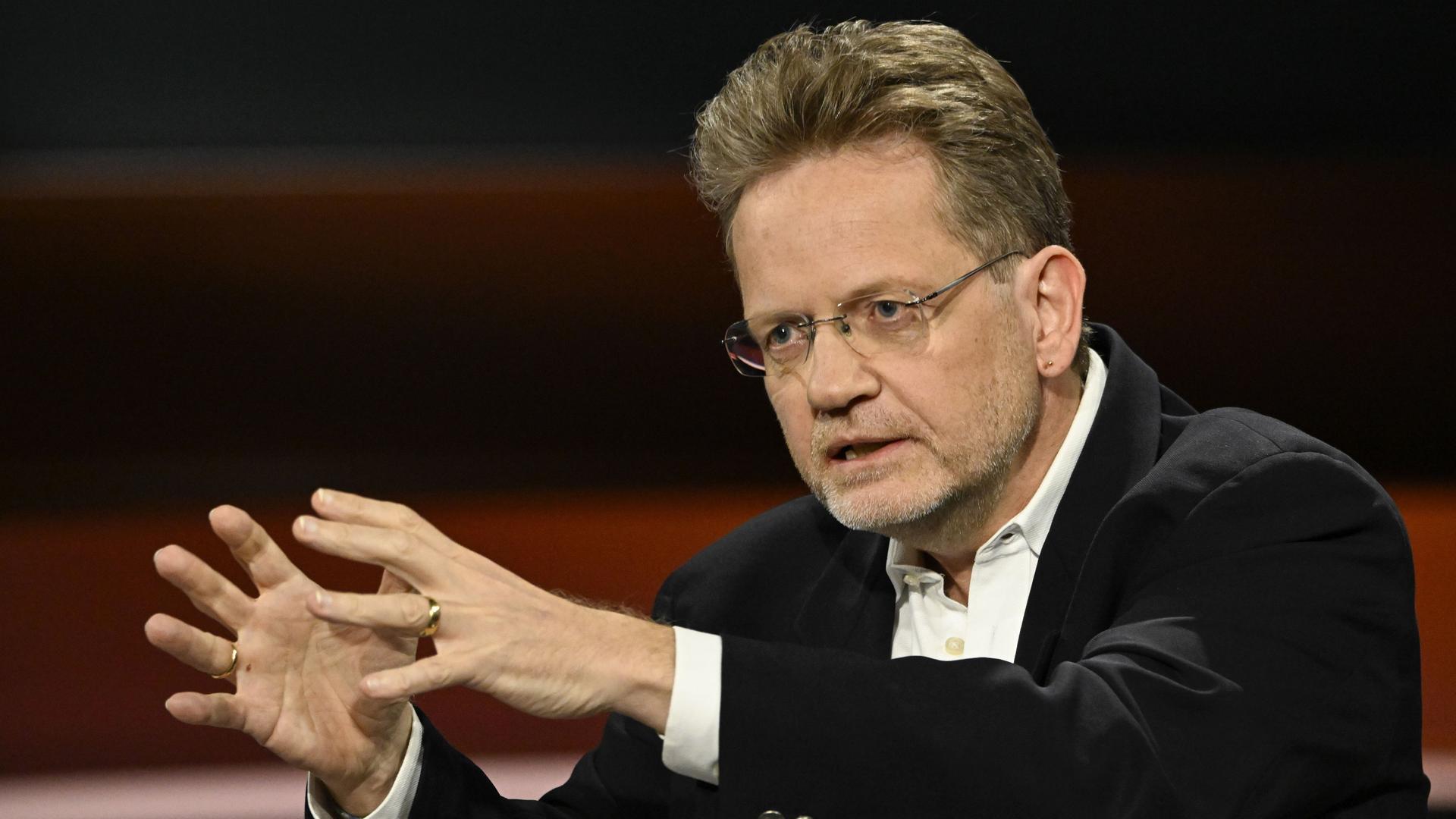 Der Jurist Kai Ambos sitzt und gestikuliert. Der Jurist Kai Ambos sitzt und gestikuliert.