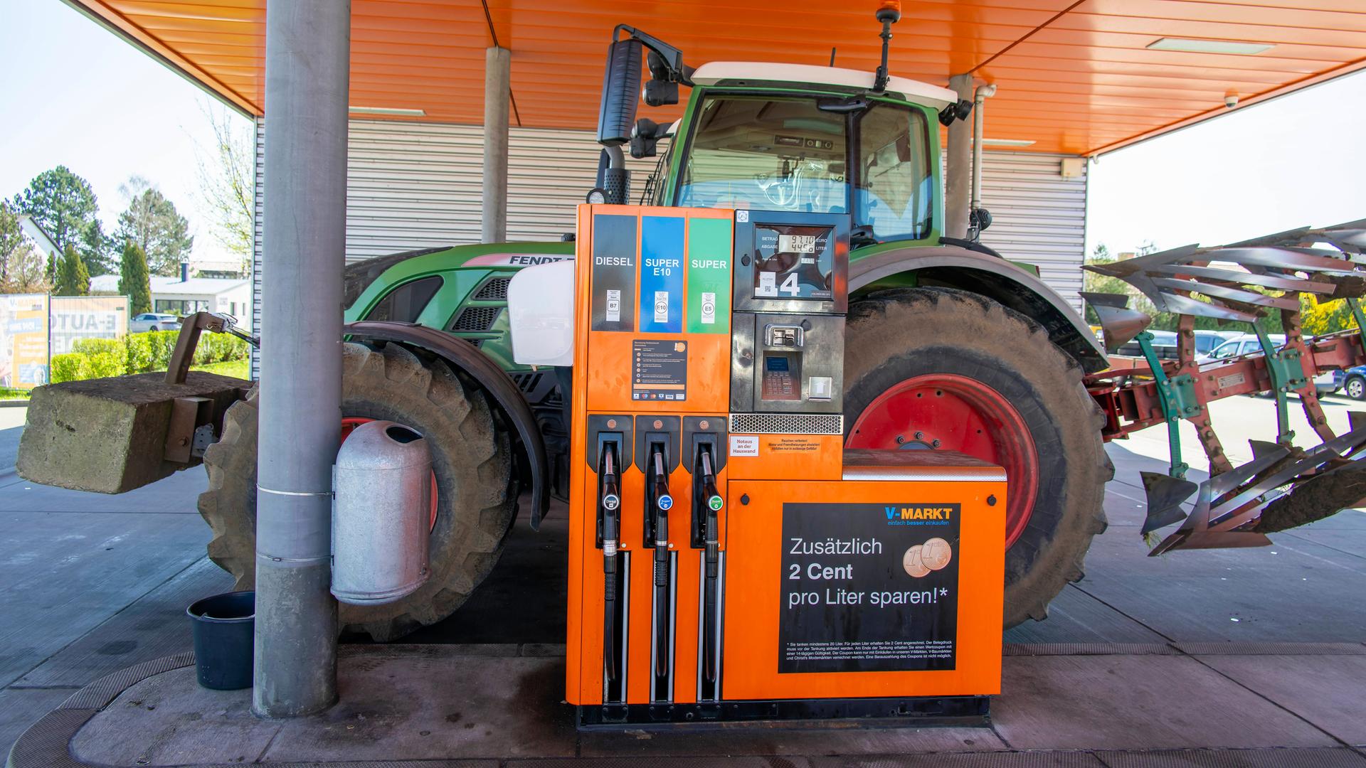 Ein Traktor steht an einer Tankstelle.