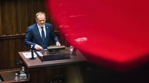 Donald Tusk steht an einem Rednerpult.
