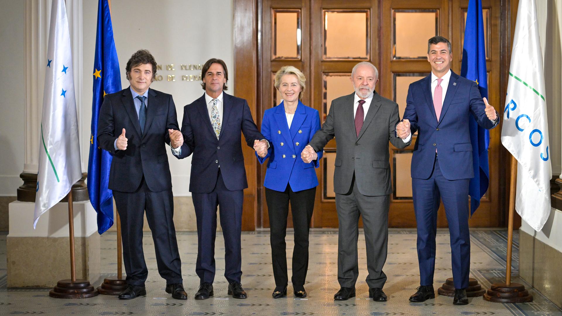 Die Staatschefs der Mercosur-Staaten und EU-Kommissionspräsidentin von der Leyen stehen nebeneinander und halten sich an den Händen.