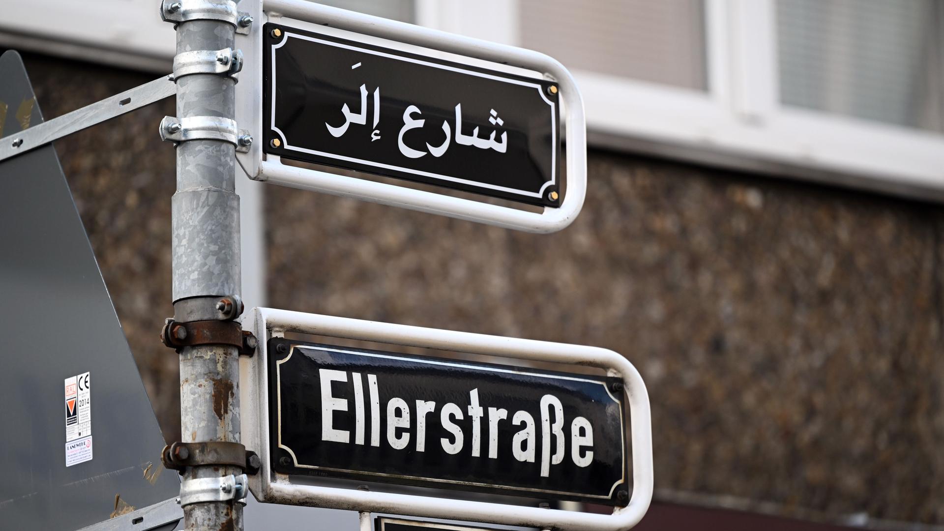 Nordrhein-Westfalen, Düsseldorf: Über dem Straßenschild "Ellerstraße" ist die arabische Version zu sehen. Ein vor wenigen Tagen installiertes Straßenschild in arabischer Schrift ist in Düsseldorf Ziel einer Attacke geworden, hinter der Rechtsextremisten vermutet werden.
