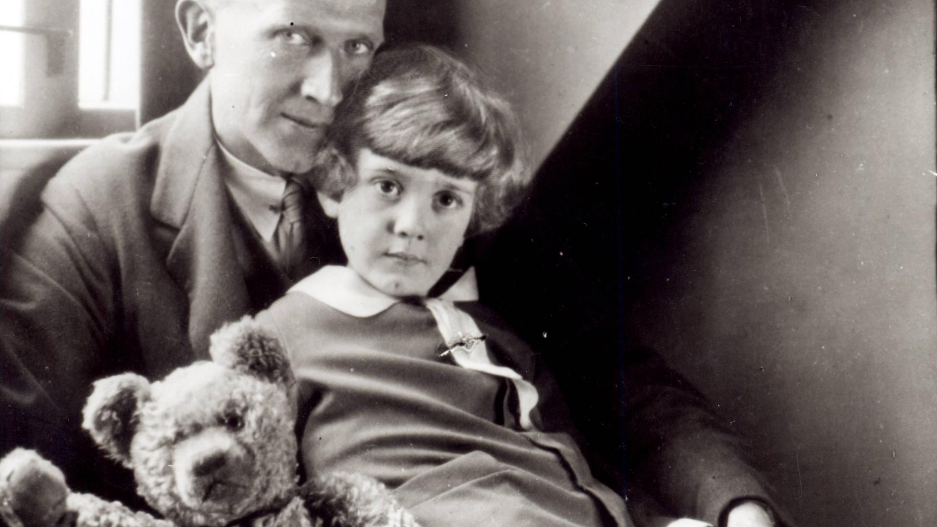 Schwarzweißfoto mit dem Autor A. A. Milne und sein Sohn Christopher Robin sowie die Plüschpuppe Winnie the Pooh. Schwarzweißfoto mit dem Autor A. A. Milne und sein Sohn Christopher Robin sowie die Plüschpuppe Winnie the Pooh.