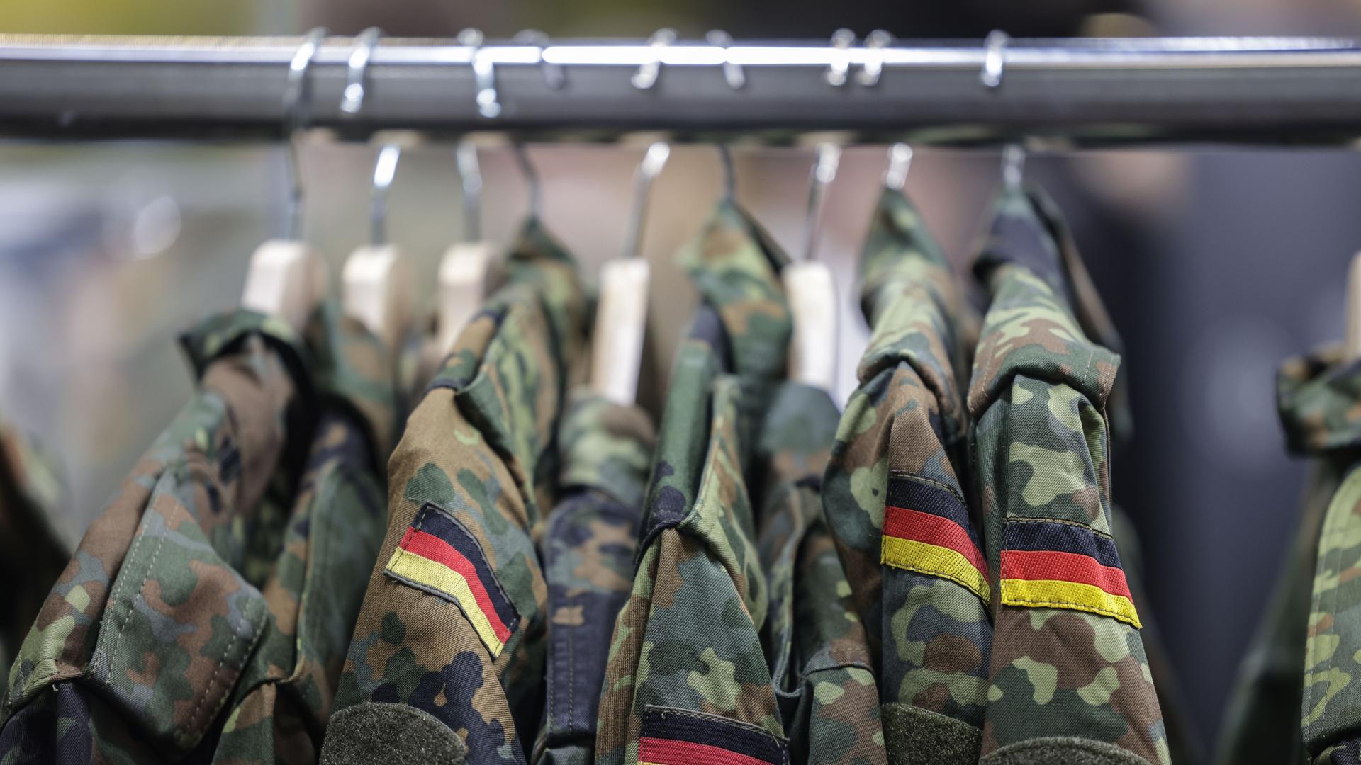 An einer Kleiderstange hängen mehrere Feldjacken der Bundeswehr. 