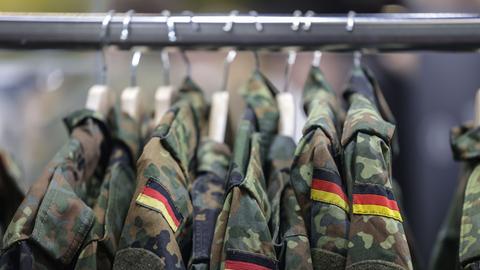 An einer Kleiderstange hängen mehrere Feldjacken der Bundeswehr. 