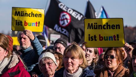 Viele Demonstranten in München gegen die AfD, einige halten Schilder hoch mit der Aufschrift "München ist bunt". 