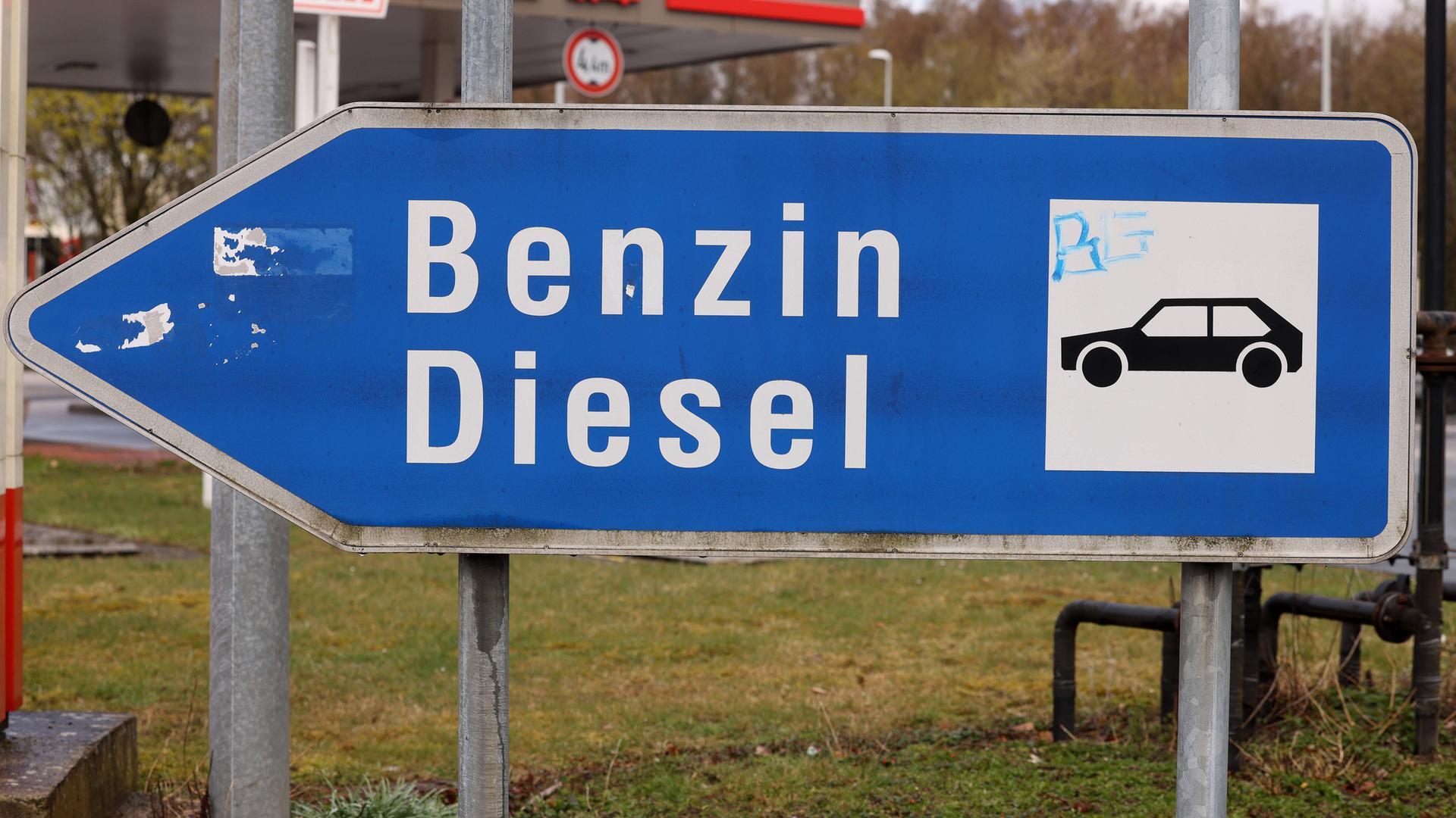 Ein Schild zeigt den Weg zu den Benzin und Diesel an einer Tank-Stelle