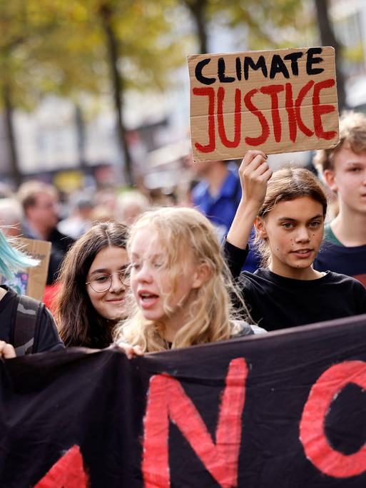 Teilnehmer der Demonstration von Fridays for Future beim sogenannten 'globalen Klimastreik' auf dem Heumarkt halten Schilder und Transparente in die Luft. Köln, 23.09.2022