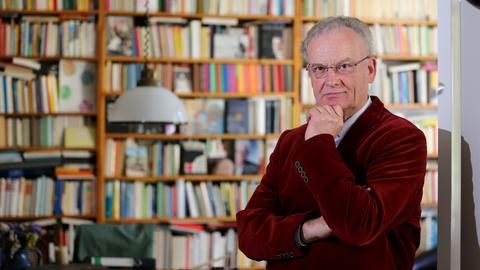 Friedrich Schorlemmer steht vor seinem Bücherregal. Er trägt ein weinrotes Jackett.