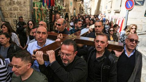 Christen tragen in Jerusalem das Kreuz Jesus am Karfreitag auf der Via Dolorosa durch die Gassen der Altstadt in Jerusalem entlang. 