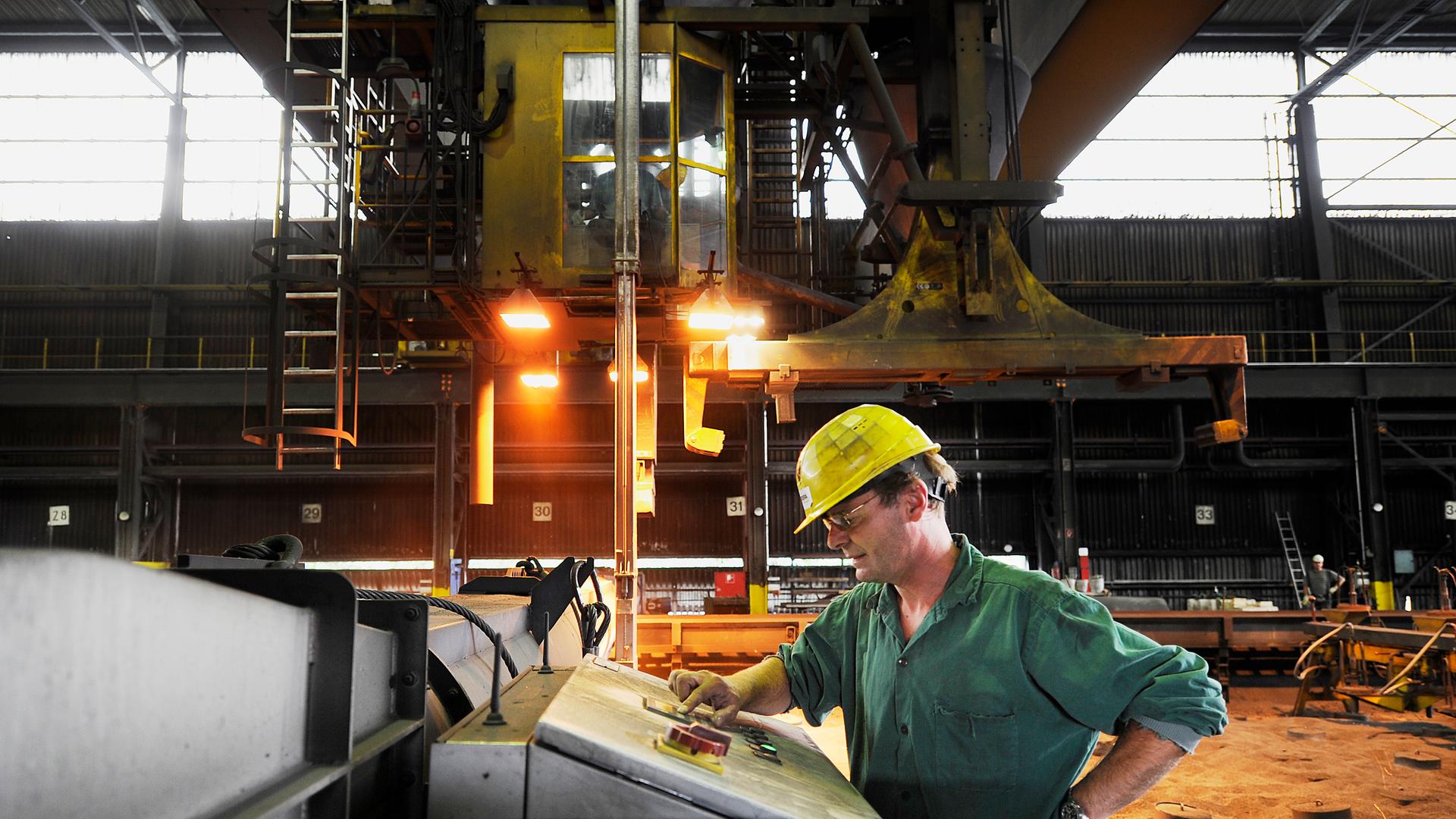 Aluminium-Werk in Voerde: ein Arbeiter überwacht eine Maschine in der Anoden-Herstellung.