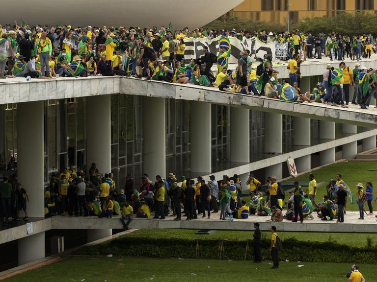 BRASILIA, BRASILIEN – 8. JANUAR: Anhänger des ehemaligen Präsidenten Jair Bolsonaro stoßen mit Sicherheitskräften zusammen, als sie den Nationalkongress in Brasilia, Brasilien, am 8. Januar 2023 überfallen. Gruppen, die Parolen riefen, die ein Eingreifen der Armee forderten, durchbrachen die Polizeibarriere und betraten das Kongressgebäude , laut lokalen Medien. Die Polizei griff mit Tränengas ein, um Pro-Bolsonaro-Demonstranten auseinanderzutreiben. Joedson Alves / Agentur Anadolu BRASILIA, BRASILIEN – 8. JANUAR: Anhänger des ehemaligen Präsidenten Jair Bolsonaro stoßen mit Sicherheitskräften zusammen, als sie den Nationalkongress in Brasilia, Brasilien, am 8. Januar 2023 überfallen. Gruppen, die Parolen riefen, die ein Eingreifen der Armee forderten, durchbrachen die Polizeibarriere und betraten das Kongressgebäude , laut lokalen Medien. Die Polizei griff mit Tränengas ein, um Pro-Bolsonaro-Demonstranten auseinanderzutreiben. Joedson Alves / Agentur Anadolu