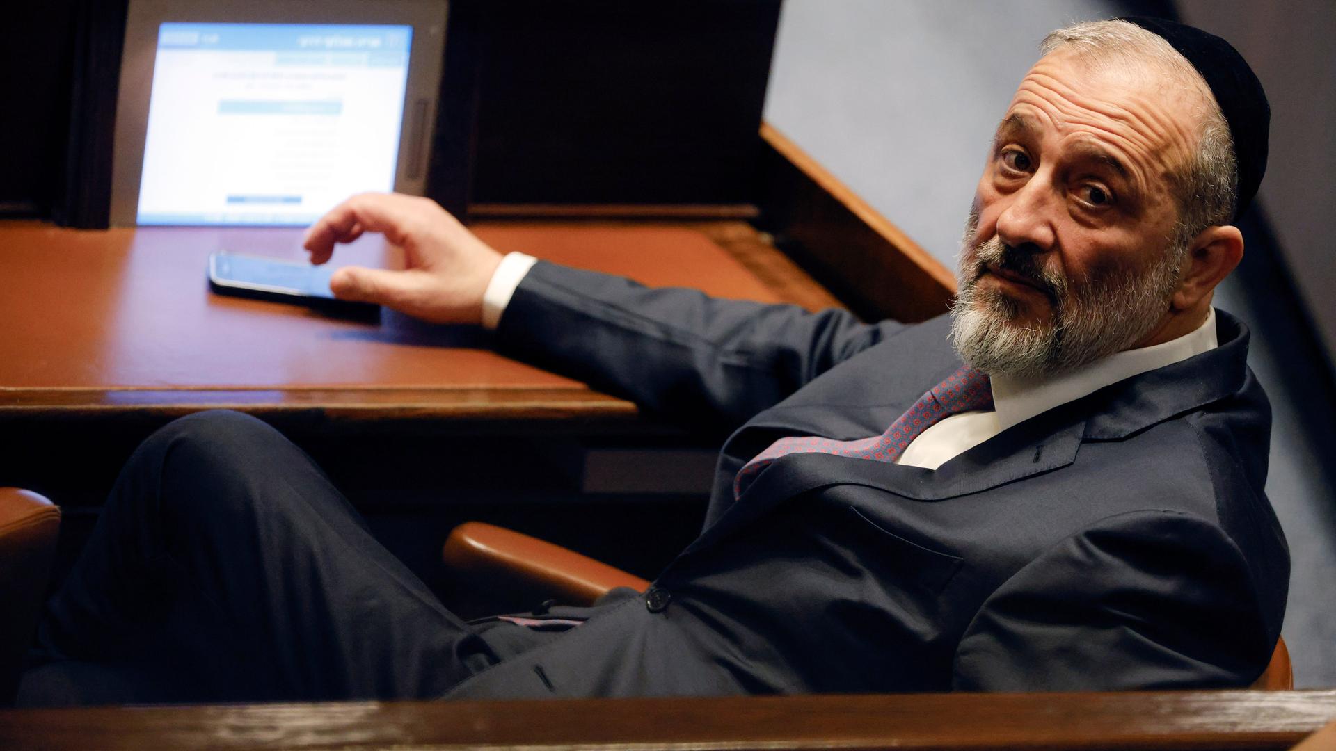 Aryeh Deri sitzt in der Knesset auf einer Bank. Aryeh Deri sitzt in der Knesset auf einer Bank.