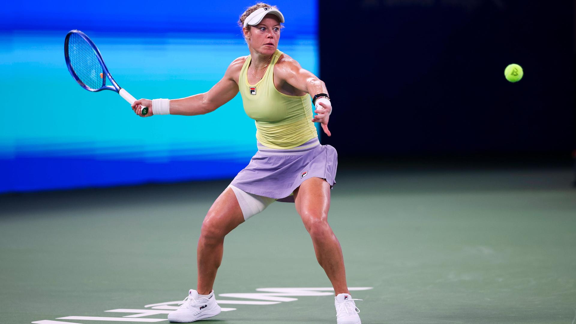 Laura Siegemund hat einen Tennisschläger in der Hand. Sie holt weit aus und blickt konzentriert auf einen Ball vor ihr. 