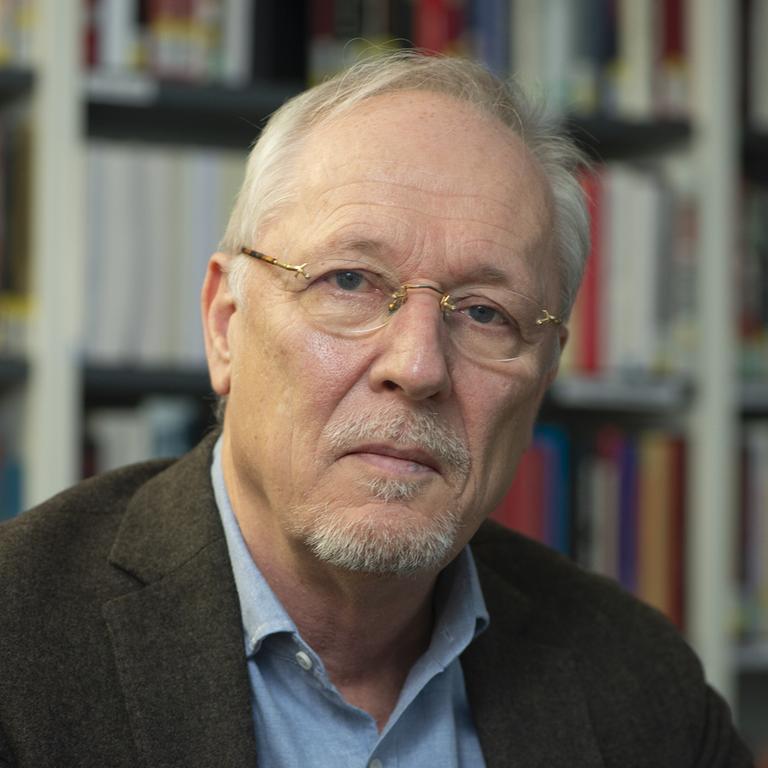 Porträt des Historikers Jörg Baberowski vor einem Buchregal