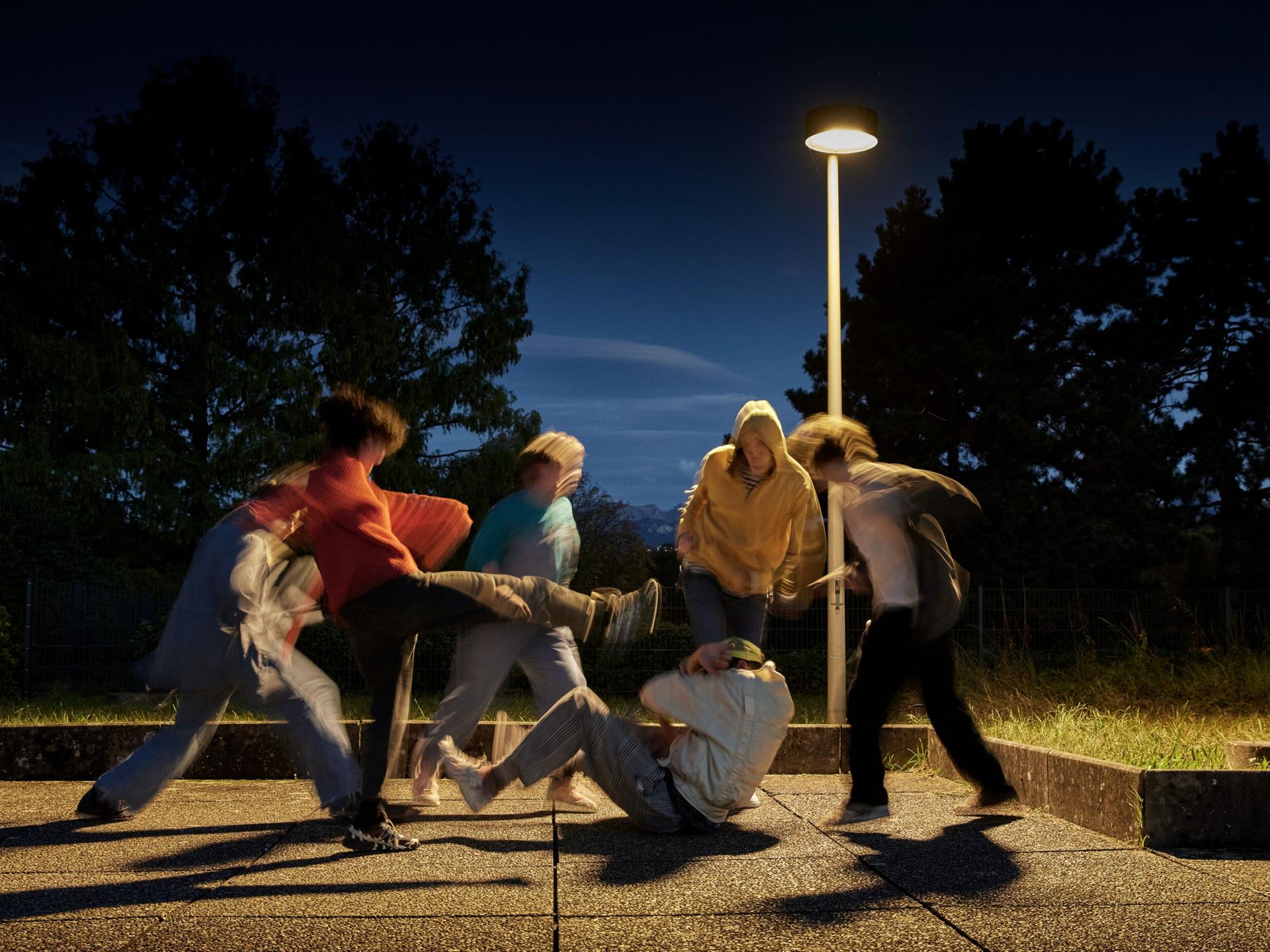 Ein am Boden liegender Jugendlicher wird von einer Gruppe Jugendlicher getreten. (Symbolbild, gestellte Szene)